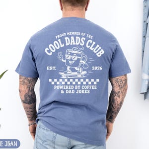 Comfort Colors 1717 Blue Jean t-shirt on male model featuring a white Cool Dads Club coffee mug Powered by Coffee graphic, soft unisex fit, garment dyed cotton texture, vintage washed tee for personalized dad gifts, Father's Day shirts, family style.