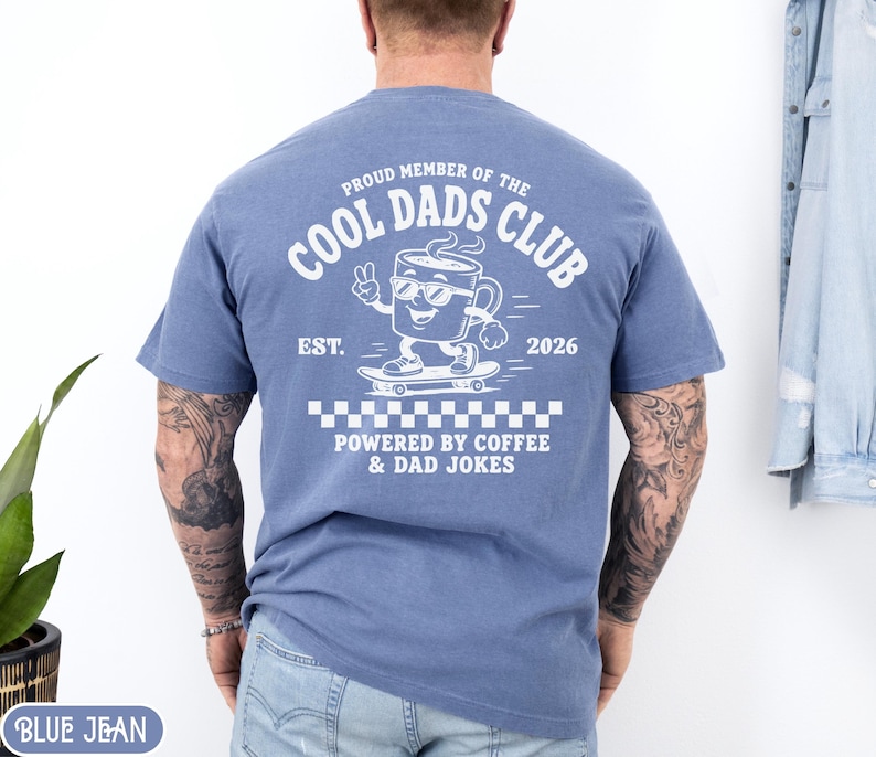 Comfort Colors 1717 Blue Jean t-shirt on male model featuring a white Cool Dads Club coffee mug Powered by Coffee graphic, soft unisex fit, garment dyed cotton texture, vintage washed tee for personalized dad gifts, Father's Day shirts, family style.