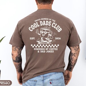 Comfort Colors 1717 Espresso t-shirt on male model featuring a white Cool Dads Club coffee mug Powered by Coffee graphic, soft unisex fit, garment dyed cotton texture, vintage washed tee for personalized dad gifts, Father's Day shirts, family style.