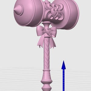 Op de afbeelding: Een lichtroze 3D-model van een hamer met een cilindrische kop met een punt aan &eacute;&eacute;n kant en een hartvormig embleem in het midden. Het handvat is versierd met een strik en een hartdetail en heeft een gedraaid textuurontwerp.