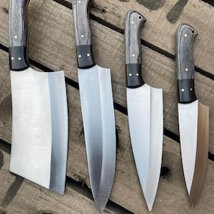 May include: A set of four kitchen knives with silver-toned metal blades and dark grey wood-grain handles. Each knife features a black bolster, brass rivets, and a lanyard hole at the end of the handle. The blades vary in shape from a wide cleaver to smaller pointed blades.