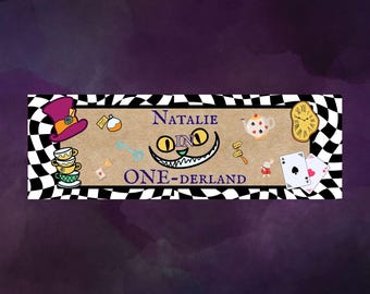 May include: A rectangular banner with a black and white checkered border featuring the text Natalie IN ONE-DERLAND. The design includes a purple top hat, stacked teacups, a key, a teapot, a melting clock, playing cards, and a grinning cat face.