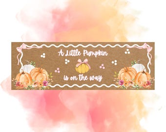 May include: A rectangular sign with a brown background and white scalloped border featuring the text A Little Pumpkin is on the way. The design includes watercolour illustrations of orange and white pumpkins, pink bows, and floral accents.