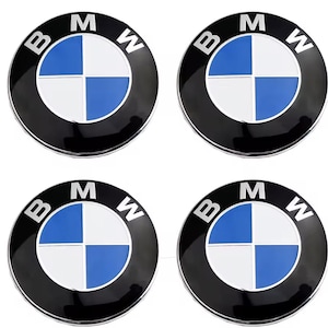 以下が含まれることがあります： 黒い外輪に白い文字が刻まれた、4つの円形BMWエンブレムのセット。中央は4つの象限に分かれており、青と白の色が交互に配置されています。各エンブレムは滑らかで光沢のある仕上げで、金属製の縁取りが施されています。
