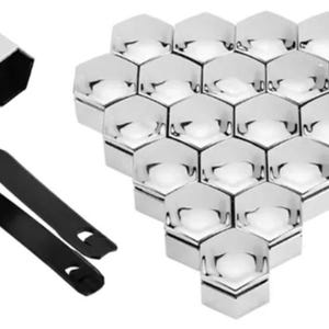 Puede incluir: Un juego de tuercas hexagonales plateadas, junto con una herramienta negra para quitarlas. Las tuercas están dispuestas en forma de panal, con una tuerca separada. La herramienta es negra y tiene un diseño curvo con dos aberturas.