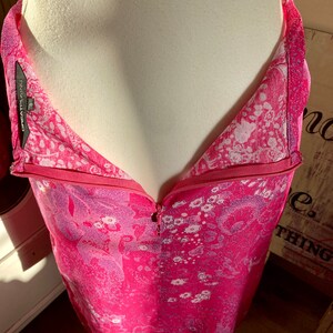 Puede incluir: Un vestido rosa sin mangas con estampado floral y cierre de cremallera. El vestido tiene un escote en V y una silueta ajustada. La etiqueta de la marca dice "Great Plains 8".