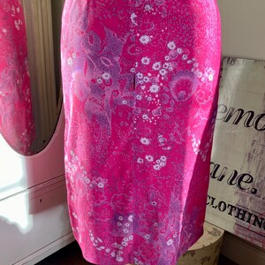 Puede incluir: Una falda rosa con estampado floral. La falda tiene una cremallera en la parte posterior.