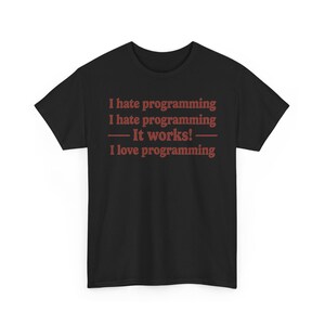K&ouml;nnte beinhalten: Ein schwarzes kurz&auml;rmeliges T-Shirt mit rotem Text, der lautet: I hate programming, I hate programming, &mdash; It works! &mdash;, I love programming. Das T-Shirt hat einen Rundhalsausschnitt und eine Standardpassform, wobei der Text mittig auf der Brust steht.