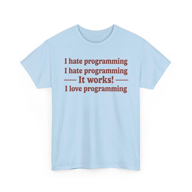 K&ouml;nnte beinhalten: Ein hellblaues Kurzarm-T-Shirt mit dunkelrotem Textaufdruck in der Mitte: I hate programming, I hate programming, &mdash; It works! &mdash;, I love programming. Das Shirt verf&uuml;gt &uuml;ber einen Rundhalsausschnitt und eine klassische, gerade Passform.