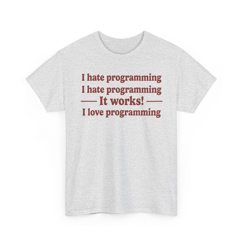 K&ouml;nnte beinhalten: Ein hellgraues kurz&auml;rmeliges T-Shirt mit dunkelrotem Text, der lautet: I hate programming, I hate programming, &mdash; It works! &mdash;, I love programming. Das T-Shirt hat einen Rundhalsausschnitt und eine Standardpassform mit mittigem Text.
