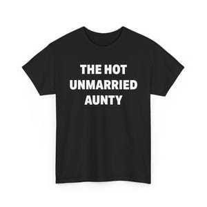 May include: A black short-sleeved t-shirt featuring the text THE HOT UNMARRIED AUNTY printed in white capital letters across the center of the chest. The garment has a crew neckline and a standard fit, showcasing a simple and bold graphic design.