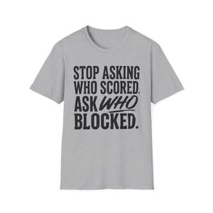 May include: A heather gray short-sleeve t-shirt featuring black text printed on the front that reads: STOP ASKING WHO SCORED. ASK WHO BLOCKED. The shirt has a crew neckline and a standard fit, constructed from a soft, textured fabric material.