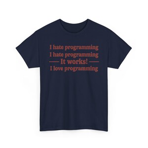 K&ouml;nnte beinhalten: Ein dunkelblaues T-Shirt mit kurzen &Auml;rmeln und rotem Text, der lautet: I hate programming, I hate programming, &mdash; It works! &mdash;, I love programming. Das T-Shirt hat einen Rundhalsausschnitt und eine Standardpassform mit mittigem Text auf der Brust.