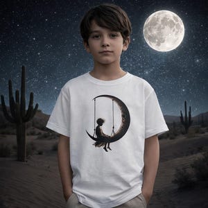 Young Boy Barefoot Sitting On A Crescent-Moon Swing | Unisex Heavy Cotton Tee