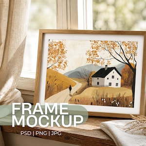 Könnte beinhalten: Ein gerahmter Kunstdruck mit einer Landschaftsszene mit einem weißen Haus, einer Person, die einen Hund ausführt, und Herbstlaub. Der Rahmen ist aus hellem Holz. Der Text "FRAME MOCKUP" ist sichtbar.