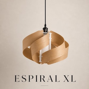May include: A modern pendant light fixture with a spiral design. The light features a black ceiling mount and cord, with a light wood shade. The text "ESPIRAL XL" and "LUZ QUE ENVUELVE" are displayed below the light.