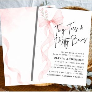 May include: A white baby shower invitation card featuring a watercolor illustration of a large, flowing pink ribbon bow with small floral sprigs. The text reads: Tiny Toes & Pretty Bows, Please join us for a baby shower to celebrate Olivia Anderson.
