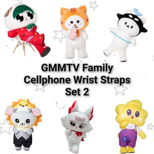 May include: Six plush character figures arranged in two rows with the text GMMTV Family Cellphone Wrist Straps Set 2 in the center. The characters include a red-clad figure, a cat-hooded plush, a black and white bear, a lion-maned bear, a white fox, and a yellow flower-shaped character.