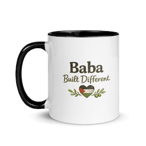 May include: White ceramic mug with a black handle and interior. The mug features the text "Baba Built Different" in brown lettering, along with a heart-shaped design in the colors of the Palestinian flag and olive branches.