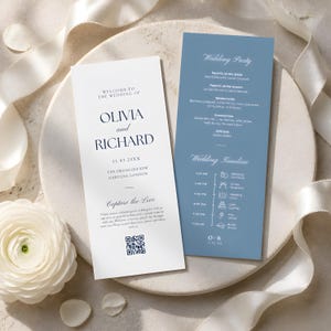 Puede incluir: Un conjunto de programa de boda de dos piezas que incluye una tarjeta blanca con texto azul oscuro que dice Olivia and Richard, 11.03.20XX, y un código QR, junto a una tarjeta azul polvoriento que detalla el cortejo y un cronograma con iconos.