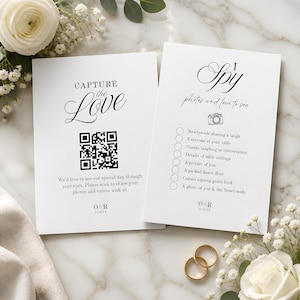 May include: Two white rectangular wedding cards with black text. The left card features a QR code, the text CAPTURE the Love, and O&R 11.03.XX. The right card features the text I Spy, a camera icon, a checklist, and O&R 11.03.XX.