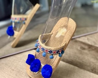 Sandalias planas tejidas color canela para mujer con pompón azul. Tallas estadounidenses: 8-8 1/2.