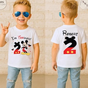 May include: White toddler t-shirt with a Mickey Mouse design for a second birthday. The front says "I'm Twoodles!" with Mickey and the number 2. The back has the name "Robert" and a Mickey Mouse-themed number 2.