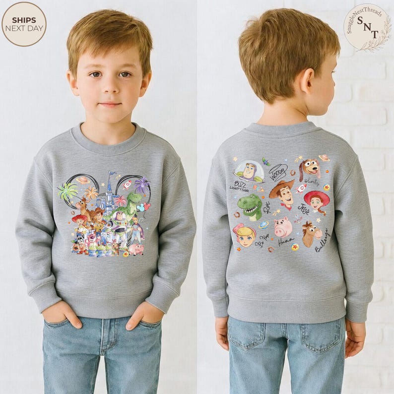 Puede incluir: Una sudadera gris jaspeado de cuello redondo con un gr&aacute;fico frontal de varios personajes animados dentro de una silueta de Mickey Mouse y un gr&aacute;fico trasero que muestra retratos individuales de Buzz Lightyear, Woody y Jessie.