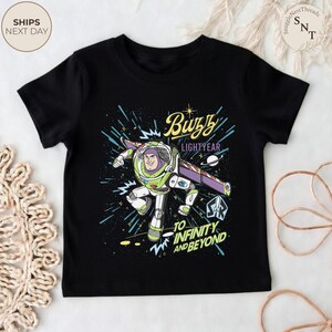 Puede incluir: Camiseta negra con un gr&aacute;fico colorido de Buzz Lightyear en movimiento. El dise&ntilde;o incluye el texto "Buzz Lightyear" y "To Infinity and Beyond". Una prenda de vestir para ni&ntilde;os.