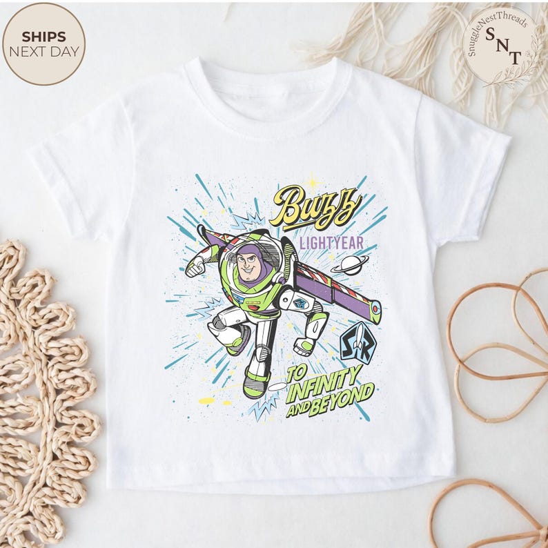 Puede incluir: Camiseta blanca con un gr&aacute;fico de Buzz Lightyear. El dise&ntilde;o incluye el texto "Buzz Lightyear" y "&iexcl;Hasta el infinito y m&aacute;s all&aacute;!" con una colorida ilustraci&oacute;n del personaje en acci&oacute;n.