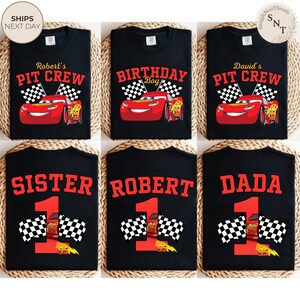 May include: Black t-shirts with various designs featuring the animated character Lightning McQueen from the movie Cars. Designs include "Robert's Pit Crew", "Birthday Boy", "David's Pit Crew", "Sister", "Robert", and "Dada". Each design includes a number 1 and checkered flags.