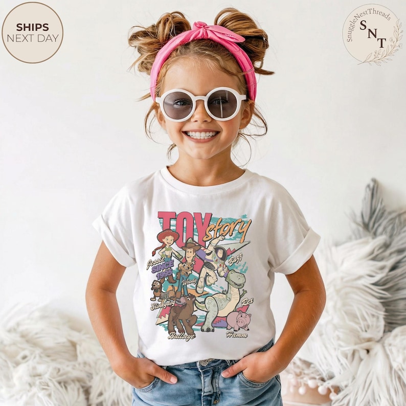 Puede incluir: Una camiseta blanca de manga corta con un estampado gr&aacute;fico colorido de los personajes de Toy Story, incluyendo a Woody, Buzz Lightyear, Jessie, Rex, Slinky Dog, Bullseye y Hamm, con el texto Toy Story y los nombres de los personajes.