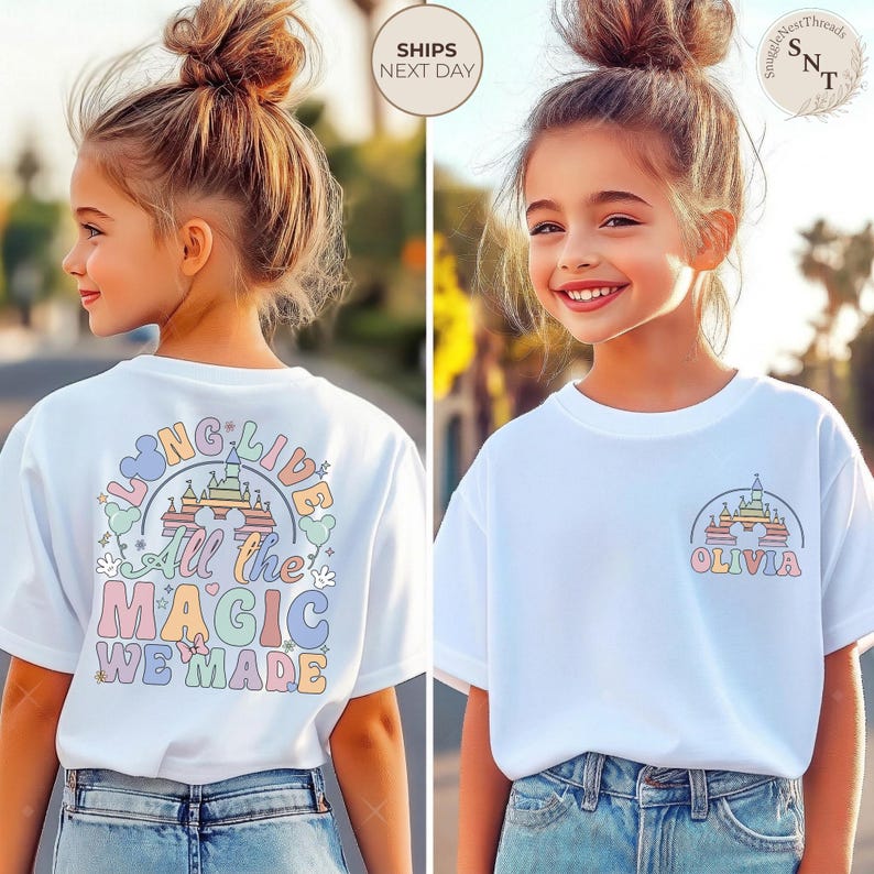 May include: White t-shirt with a colorful castle graphic and the name "Olivia" printed on the front. The back of the shirt features the text "Long Live All the Magic We Made" in pastel colors. The shirt is worn by a young girl.