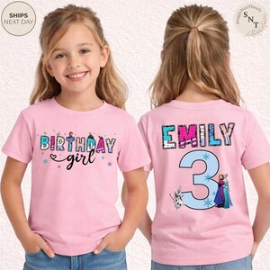 K&ouml;nnte beinhalten: Rosafarbenes T-Shirt mit kurzen &Auml;rmeln und dem Schriftzug "BIRTHDAY girl" in einem farbenfrohen Design auf der Vorderseite. Auf der R&uuml;ckseite stehen der Name "EMILY" und die Zahl "3" mit Zeichentrickfiguren.