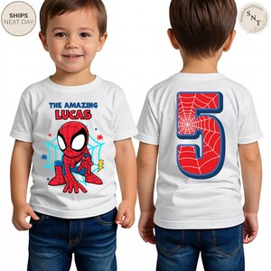 Puede incluir: Camiseta blanca con un dise&ntilde;o de Spider-Man y el texto "THE AMAZING LUCAS". La parte trasera de la camiseta muestra un gran n&uacute;mero 5 rojo con un dise&ntilde;o de telara&ntilde;a. El dise&ntilde;o de Spider-Man incluye un traje rojo y azul y una telara&ntilde;a.