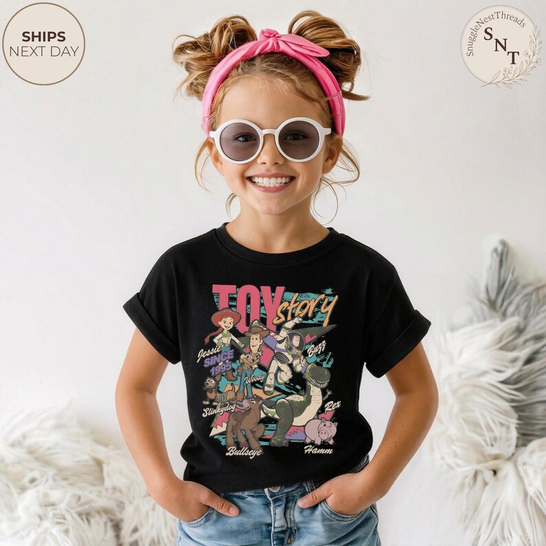 Puede incluir: Una camiseta negra de manga corta con un estampado gr&aacute;fico colorido de los personajes de Toy Story, incluyendo a Woody, Buzz Lightyear, Jessie, Rex, Hamm, Bullseye y Slinky Dog, con el texto Toy Story y los nombres impresos en varios colores.
