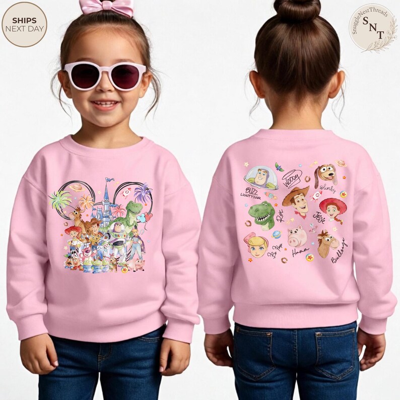 Puede incluir: Una sudadera de manga larga de color rosa claro con un gr&aacute;fico frontal de personajes de Toy Story frente a un castillo y un gr&aacute;fico trasero con retratos individuales de Buzz Lightyear, Woody, Jessie, Rex, Hamm, Slinky y Bullseye.
