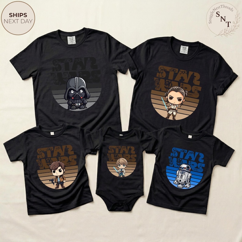 May include: Black t-shirts with Star Wars graphics featuring Darth Vader, Rey, Han Solo, a baby with a lightsaber, and R2-D2. The shirts have a retro design with a brown and blue color scheme.