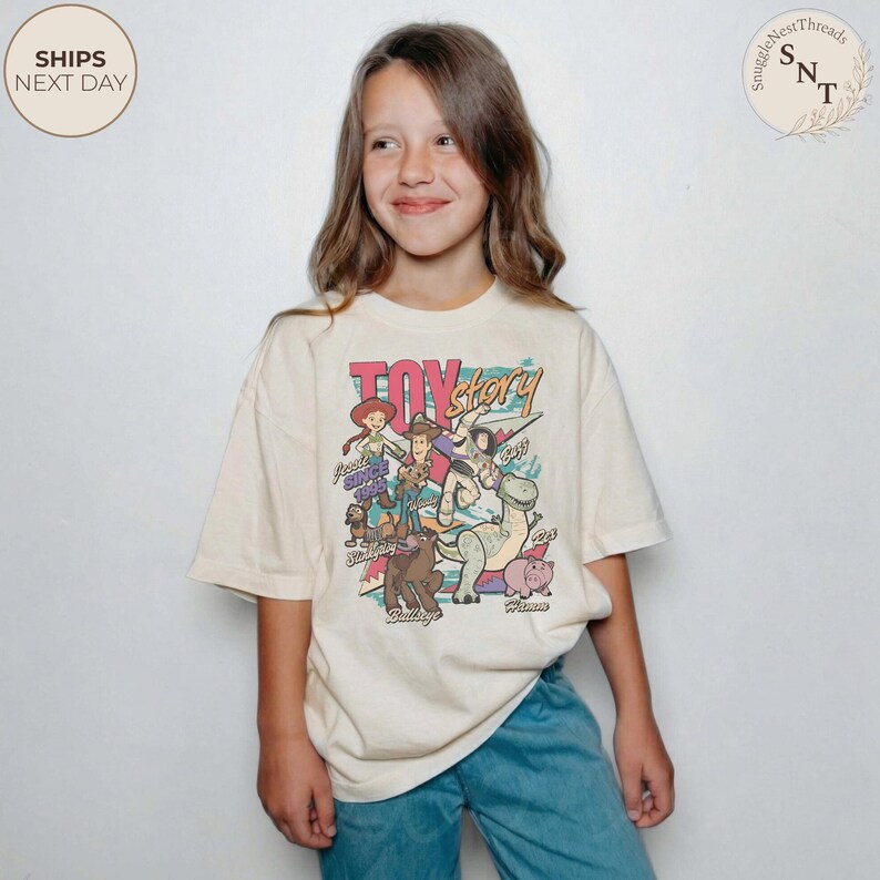 Puede incluir: Una camiseta de manga corta color crema con un estampado gr&aacute;fico colorido de los personajes de Toy Story, incluyendo a Woody, Buzz Lightyear, Jessie, Perdig&oacute;n, Rex, Slinky Dog y Hamm, con el texto Toy Story y Since 1995 impreso en el frente.