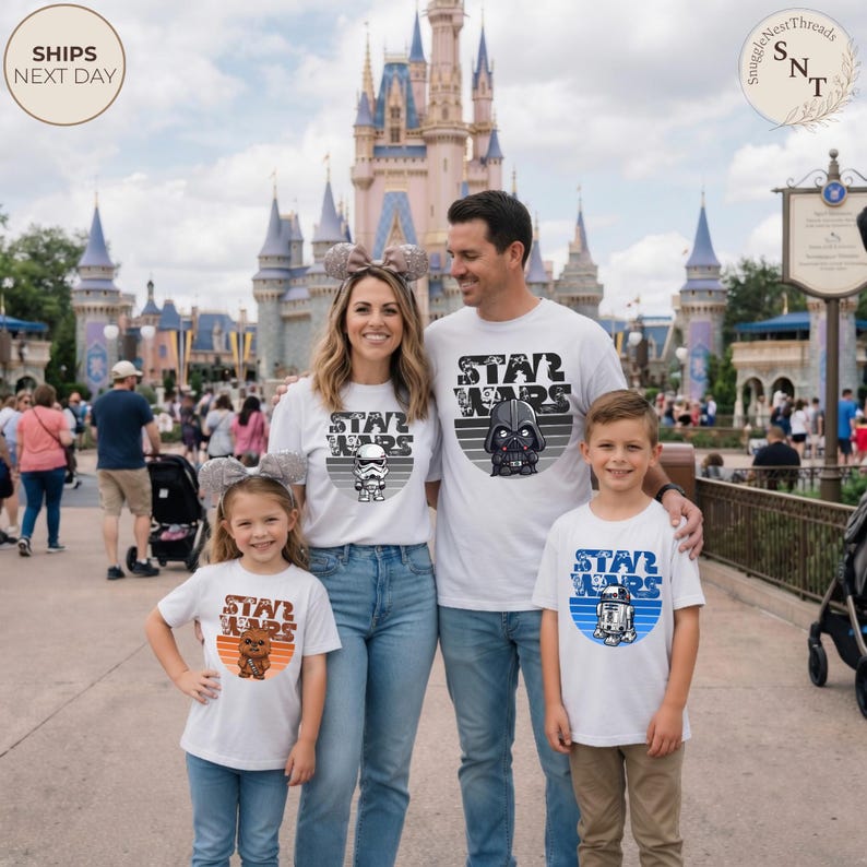 May include: A family of four wearing matching white Star Wars t-shirts posing in front of a castle. Each shirt features a different character design and the words "STAR WARS". The shirts are paired with blue jeans. The background includes a crowd of people and a sign.