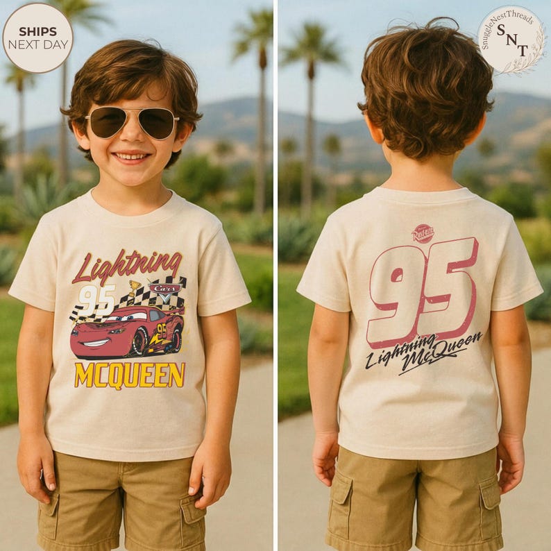 May include: A beige Lightning McQueen t-shirt with a graphic of the race car and the number 95. The front of the shirt has the text "Lightning McQueen" and "McQueen". The back of the shirt has a large number 95 and "Lightning McQueen".