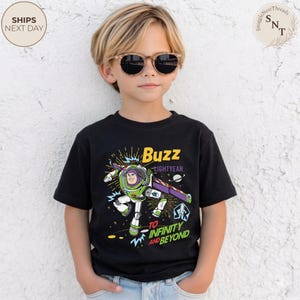Puede incluir: Camiseta negra de manga corta con un gr&aacute;fico de Buzz Lightyear de Toy Story. El dise&ntilde;o incluye el texto "Buzz Lightyear" y "To Infinity and Beyond" en amarillo y blanco. El personaje est&aacute; representado en su traje espacial verde y blanco.