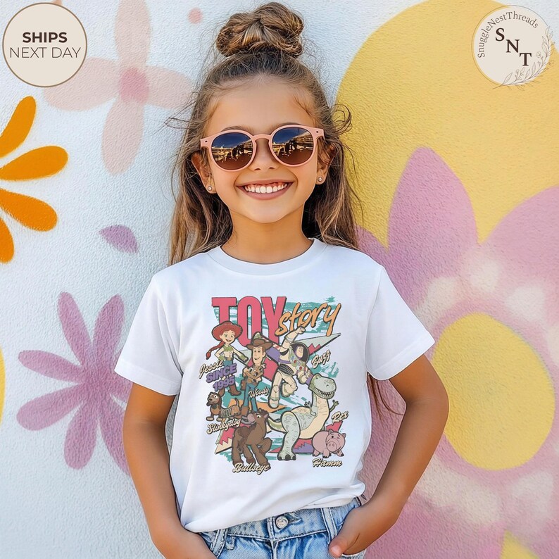Puede incluir: Una camiseta blanca de manga corta con un estampado gr&aacute;fico colorido de los personajes de Toy Story, incluyendo a Woody, Buzz Lightyear, Jessie, Rex, Slinky Dog, Bullseye y Hamm, con el texto Toy Story y los nombres de los personajes debajo.