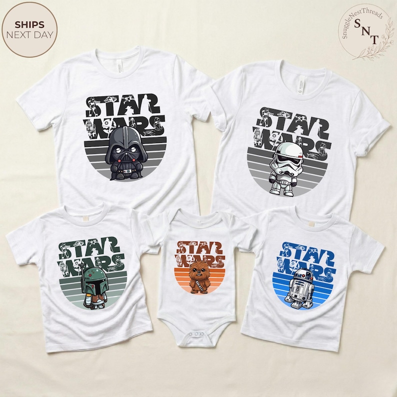 May include: White t-shirts and a onesie featuring Star Wars characters: Darth Vader, Stormtrooper, Boba Fett, Chewbacca, and R2-D2. Each shirt has a character graphic within a gray and white striped circle, with "STAR WARS" text above.