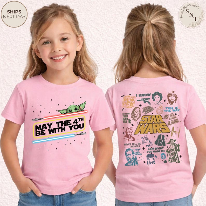 May include: Pink t-shirt featuring a graphic of Baby Yoda, lightsabers, and the text "May the 4th Be With You." The back of the shirt has Star Wars characters and quotes. A fun, themed tee.