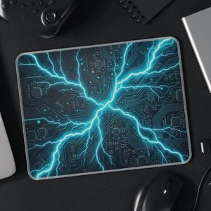 May include: A rectangular mousepad with a circuit board design and bright blue lightning bolts. The mousepad is surrounded by a laptop, mouse, external hard drive, and other tech accessories. The overall theme is technology and gaming.