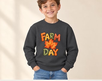 May include: A dark heather gray long-sleeve sweatshirt featuring a graphic print with the text FARM DAY in colorful bubble letters and a large orange and red autumn maple leaf centered between the words on the front of the garment.