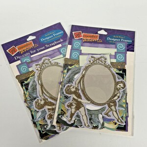May include: Two packages of "Remember When" designer die-cut scrapbook frames. Each package contains assorted designs with oval frames, cherub figures, and decorative elements in shades of gold, purple, and blue. The packaging includes text that reads "Acid Free!" and "Die-cuts for your Scrapbook."