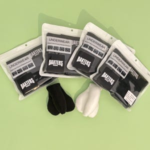 以下が含まれることがあります： Baxters Boxersとラベル付けされた黒い下着が入った3つの密封された透明なビニール袋と、黒い布製ボクサーパンツ1枚、白い布製ボクサーパンツ1枚。各袋にはUnderwearおよびModal/Cotton/Elastaneというテキストが記載されています。