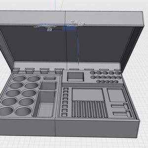 May include: A gray, open toolbox with various compartments. The interior features circular holders, rectangular slots, and a central section. The lid is partially open, revealing the internal organization. The toolbox is designed for storing tools or supplies.